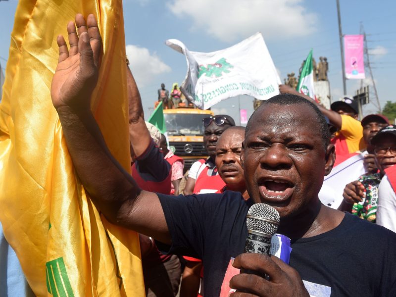 Abiodun Aremu speaks into a microphone as he takes part in a protest