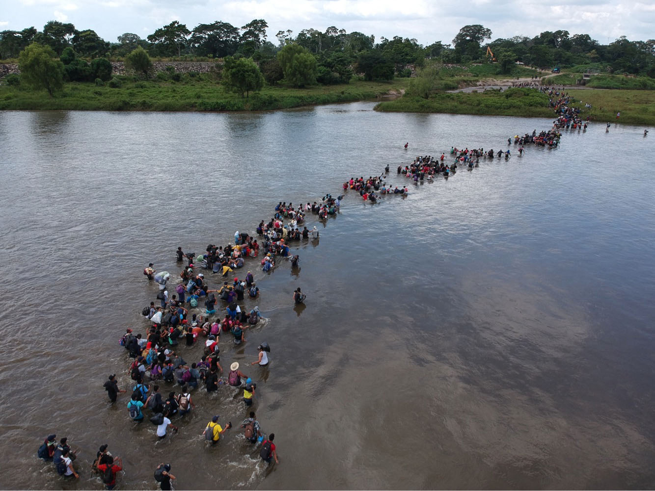 Aerial view of Salvadorean migrants heading in a caravan to the US, crossing the Suchiate River to Mexico, from Ciudad Tecun Uman, Guatemala, on November 02, 2018. Photo by CARLOS ALONZO/AFP via Getty Images