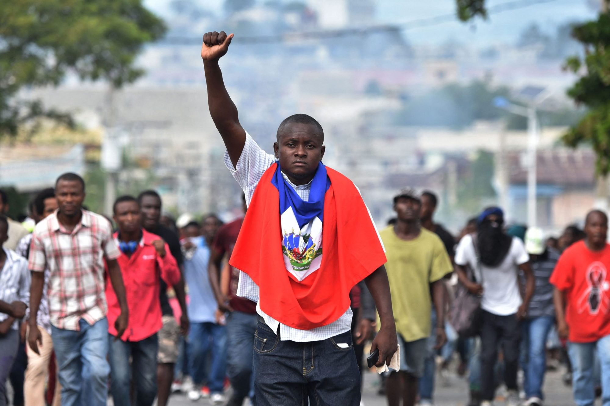 A man holds up his fist as demonstrators march through the streets of Port-au-Prince, on November 23, 2018, demanding the resignation of Haitian President Jovenel Moise. Photo by HECTOR RETAMAL/AFP via Getty Images