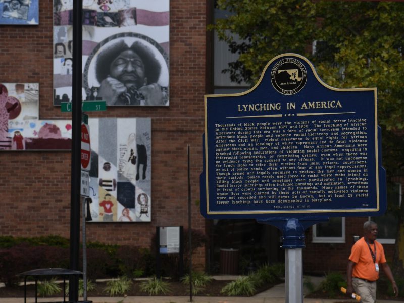 A historic marker detailing lynching in Anne Arundel County and in America at Whitmore Park on Calvert Street is seen on Sept. 17, 2019, in Annapolis, MD. The Equal Justice Initiative historical marker is the first installed in Maryland. Artwork on the building behind is a collaborative effort of George "Lassie" Belt, children from the Stanton Community Center and Artwork curator Sally Wern Comport.