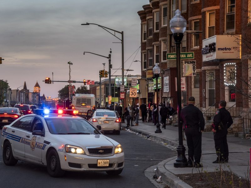 Baltimore police officers watch an argument on W. North Avenue near Pennsylvania Avenue