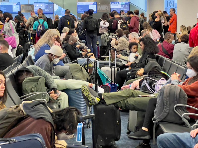 Travelers wait to board a plane at Miami International Airport in Miami, Florida, on April 22, 2022.