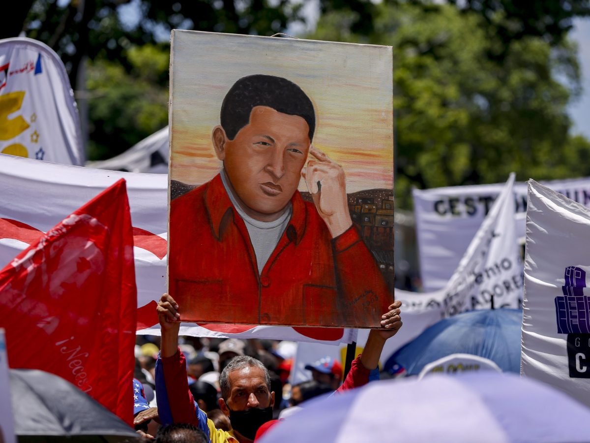 A man carries a poster of Former President of Venezuelan Hugo Chávez during a May Day (Labor Day) rally to mark the international workers' day in Caracas, Venezuela, on May 1, 2022.