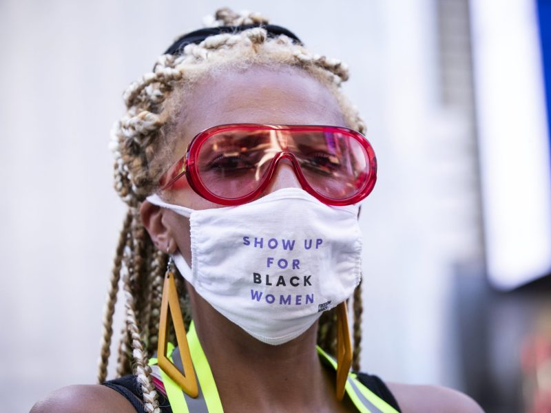 Caroline Gombe, Founder of Black Women's March, wearing a mask that says, "Show Up for Black Women" in Times Square, New York City, New York, at a rally in support of Black women on July 26, 2020.