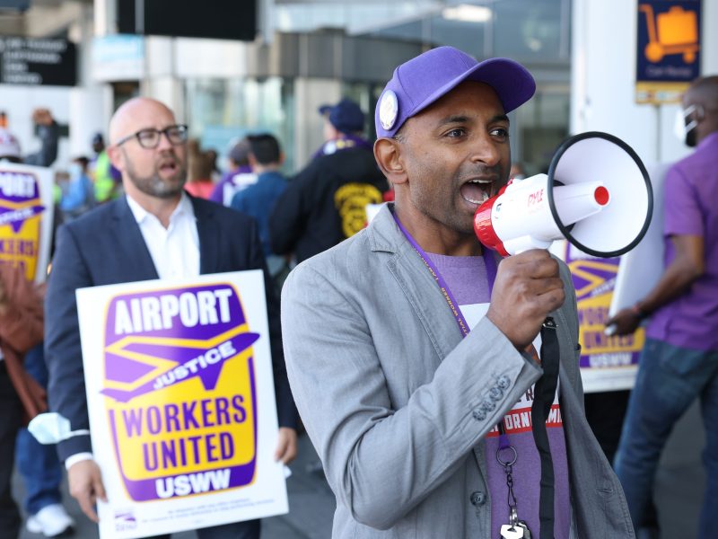 A San Francisco International Airport union worker uses a megaphone during a protest outside of the international terminal at San Francisco International Airport on September 2, 2022, in San Francisco, California. Dozens of union workers at San Francisco International Airport staged a protest ahead of the busy Labor Day travel weekend to raise concerns over low staffing levels at the airport.