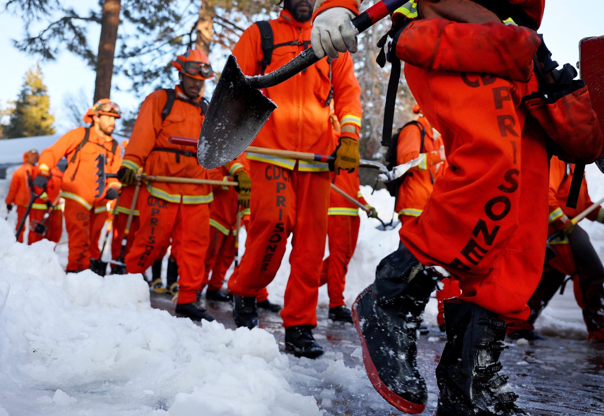 A crew of inmate firefighters walk back to their vehicle after shoveling and clearing snow after a series of winter storms in the San Bernardino Mountains in Southern California on March 3, 2023 in Crestline, California. Photo by Mario Tama/Getty Images