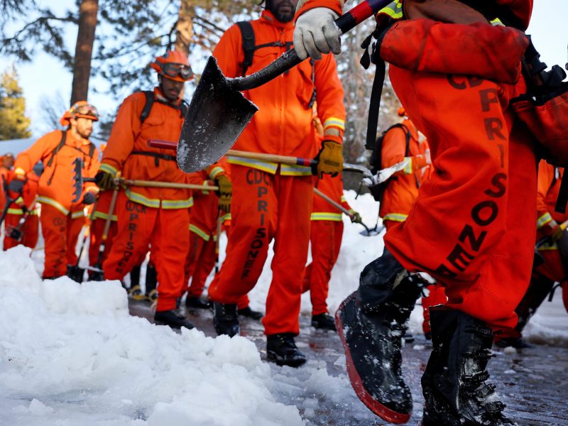 A crew of inmate firefighters walk back to their vehicle after shoveling and clearing snow after a series of winter storms in the San Bernardino Mountains in Southern California on March 3, 2023 in Crestline, California. Photo by Mario Tama/Getty Images