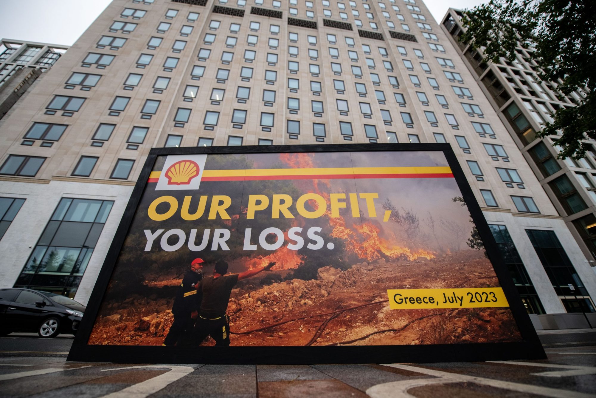 Greenpeace activists hold a billboard during a protest outside Shell headquarters amid the companies profits announcement on July 27, 2023 in London, England. Photo by Handout/Chris J Ratcliffe for Greenpeace via Getty Images