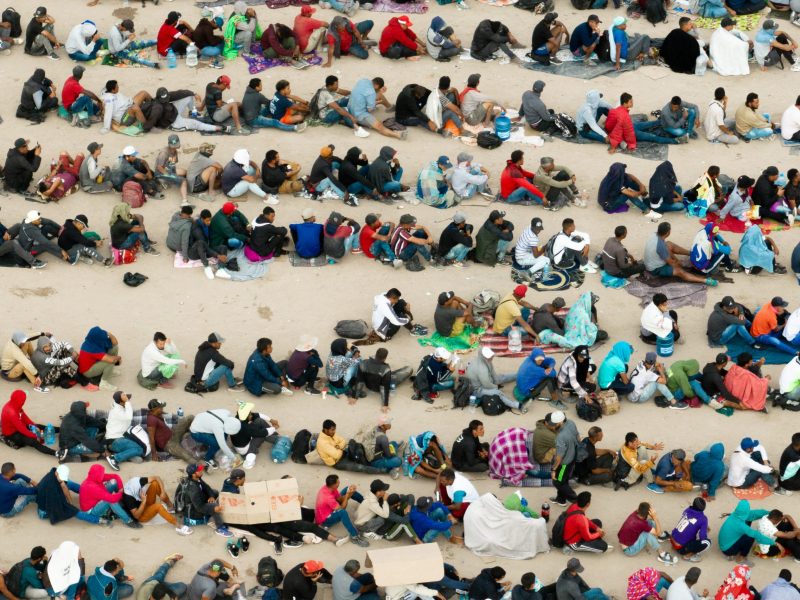 In an aerial view, migrants are seen grouped together while waiting to be processed on the Ciudad Juarez side of the border on Sept. 21, 2023, in El Paso, Texas.