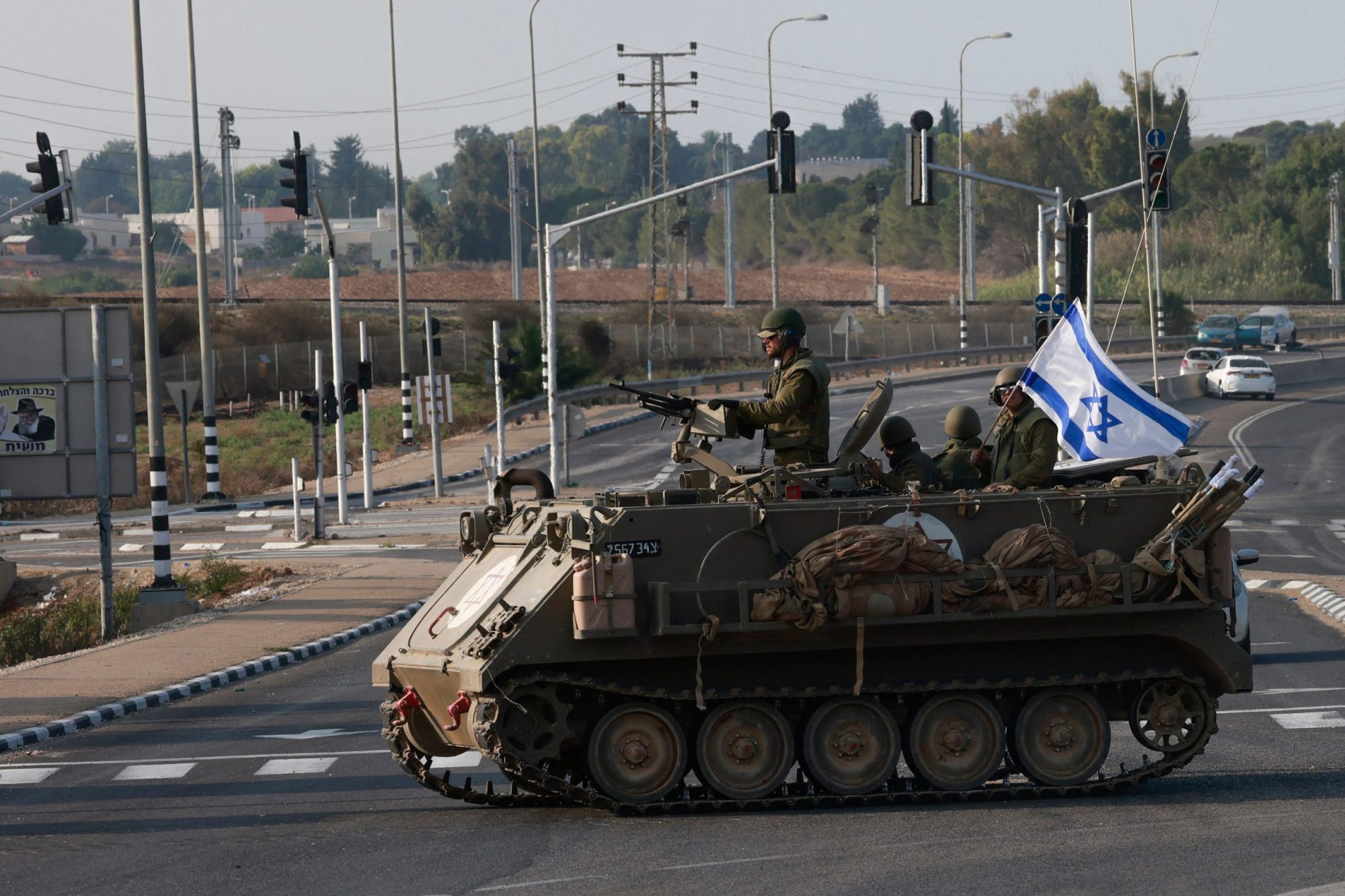 Israeli forces cross a main road in their armoured personnel carrier APC as additional troops are deployed near the southern city of Sderot on October 8, 2023. Photo by MENAHEM KAHANA/AFP via Getty Images