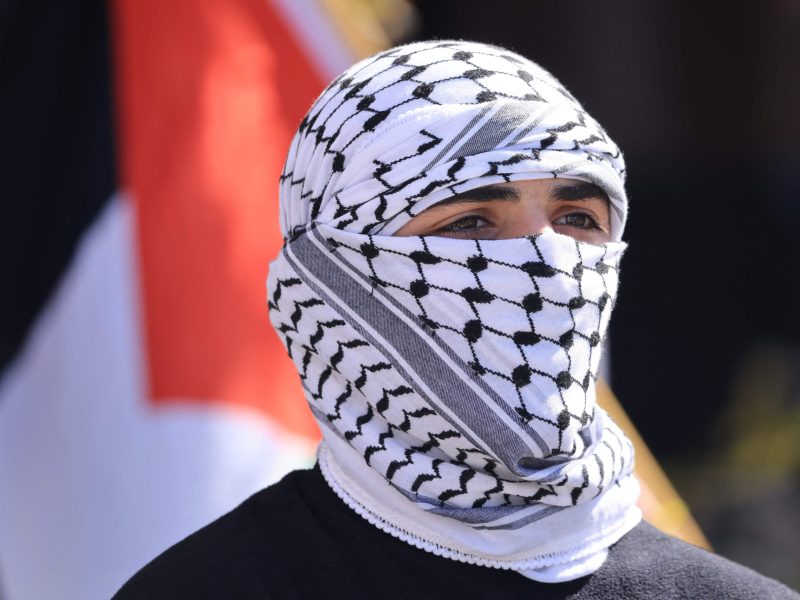 A protestor wears a Palestinian keffiyeh as he joins thousands of demonstrators waving Palestinian flags and signs denouncing "Israeli apartheid" during a march in support of Palestinians in Los Angeles on October 14, 2023. Photo by DAVID SWANSON/AFP via Getty Images