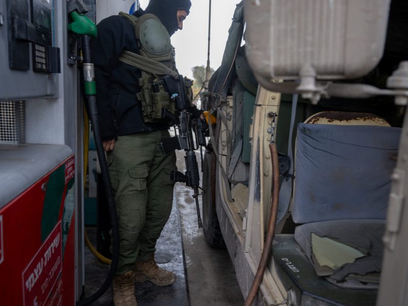 An IDF soldier fills a hummer with petrol at a petrol station near the Gaza border on November 19, 2023 in Southern Israel. Photo by Alexi J. Rosenfeld/Getty Images