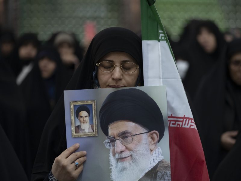 A veiled Iranian woman is reacting as she holds an Iranian flag and a poster featuring portraits of Iran's Supreme Leader Ayatollah Ali Khamenei and Late Leader Ayatollah Ruhollah Khomeini. Photo by Morteza Nikoubazl/NurPhoto via Getty Images