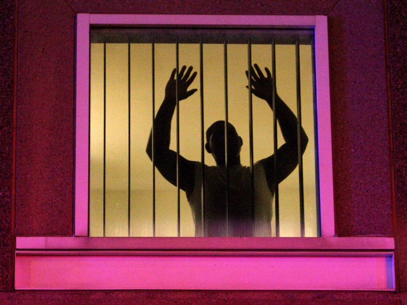 Inmate at the South Bay House of Correction joins Ferguson grand jury protestors outside with their hands-up gestures as they protest on the entrance road to I-93 near Melnea Cass Boulevard and Massachusetts Avenue in Boston, Mass. Nov. 25, 2014. Photo by John Blanding/The Boston Globe via Getty Images