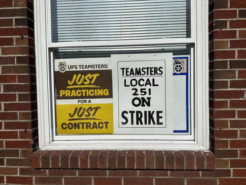 A UPS Teamsters practice picket sign and an actual Local 251 strike picket sign in the window of the Local 251 union hall.