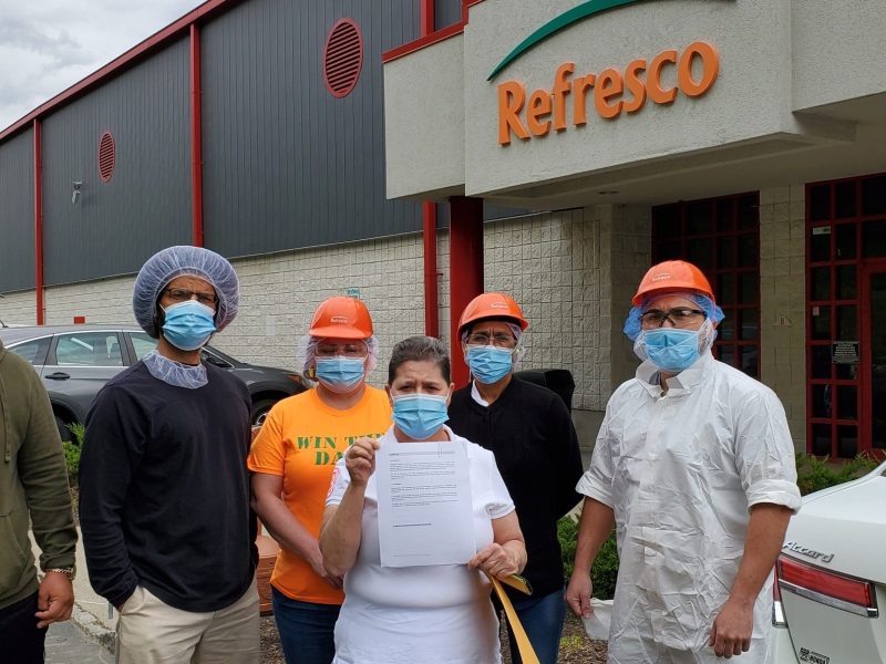 Los trabajadores de Refresco afuera de la fábrica sosteniendo una carta en la que piden a la empresa el reconocimiento voluntario poco después de presentar una solicitud de elección sindical el 3 de mayo de 2021.