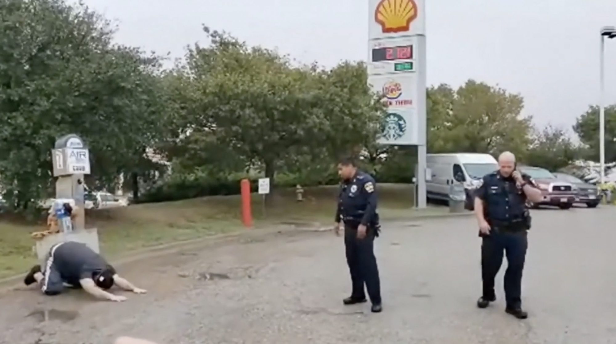 Photo of cop watcher Otto the Watchdog mockingly lying prostrate on the ground at a gas station while being confronted by Livingston, Texas, police. Photo courtesy of Winston Knowles, also known as Otto the Watchdog.