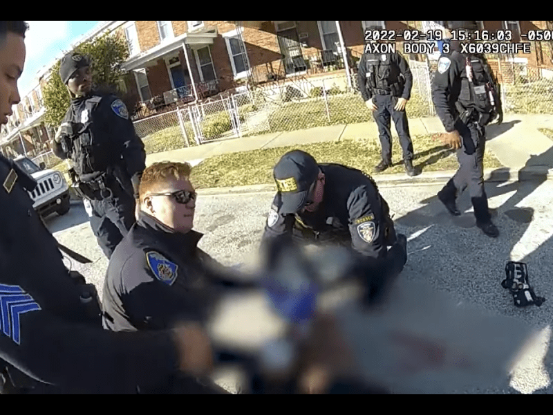 Body-worn camera footage of Baltimore Police officers surrounding Donnell Rochester on the ground.
